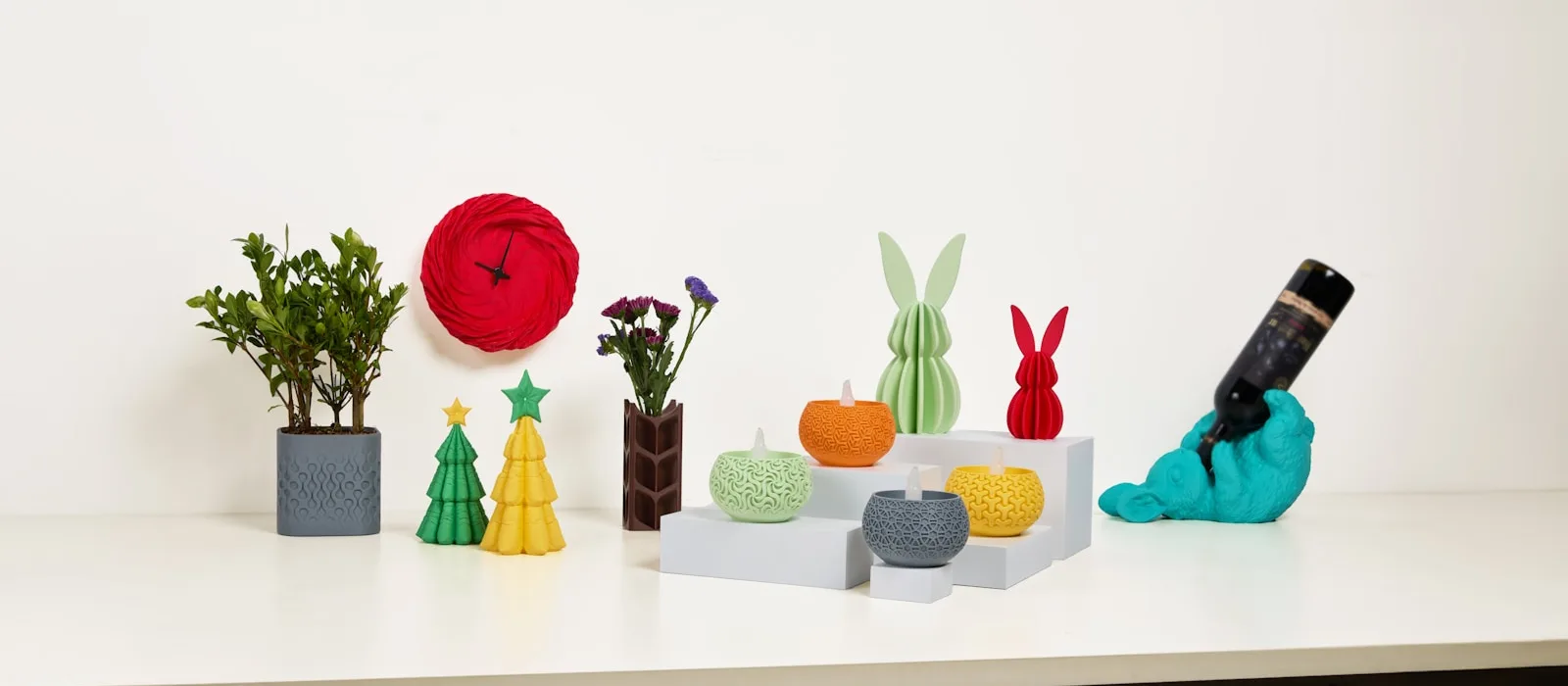 3D-printed planters, a clock and ornaments on a bright home shelf