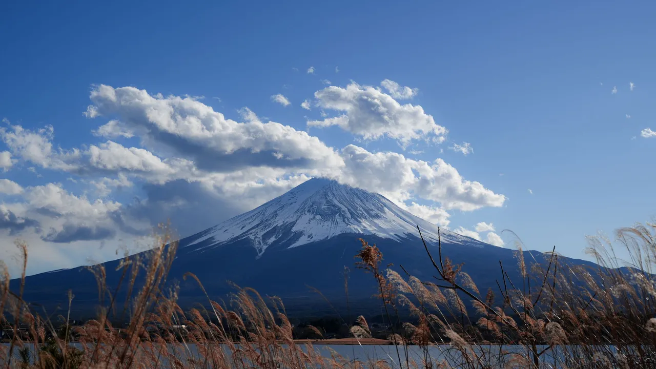 Mount Fuji rising over a lake under a blue sky
